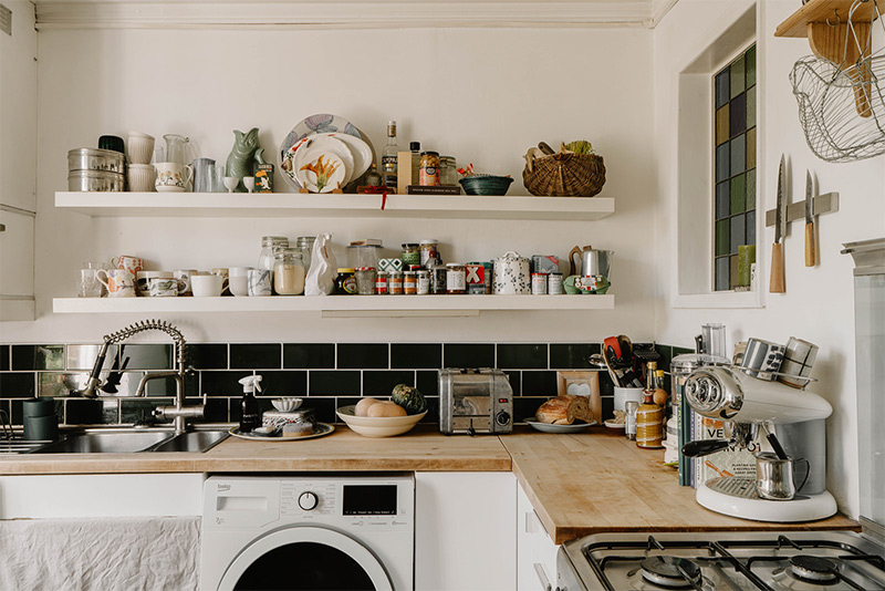 La cuisine avec son joli bric-à-brac savamment mis en scène sur les étagères murales La cuisine avec son joli bric-à-brac savamment mis en scène sur les étagères murales