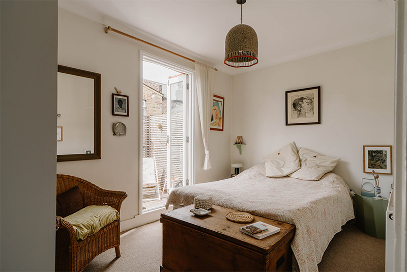 La chambre principale au style brocante épurée ouvrant sur un balcon La chambre principale au style brocante épurée ouvrant sur un balcon