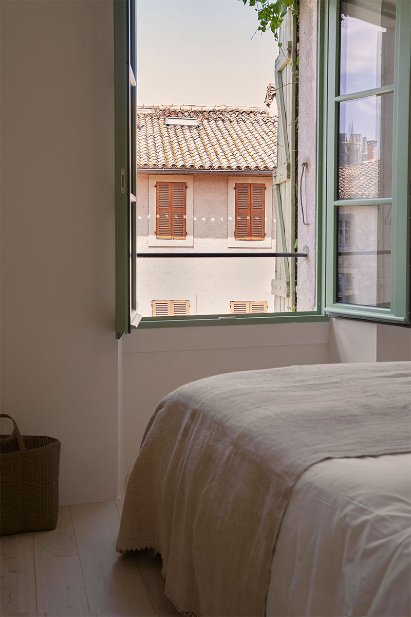 La chambre minimaliste et sa fenêtre peinte en vert