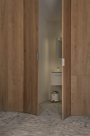 Cabinet de toilettes dissimulé derrière des panneaux de bois