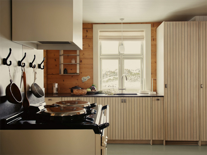 La cuisine avec des portes en placage de lamelles de bois avec un plan de travail noir