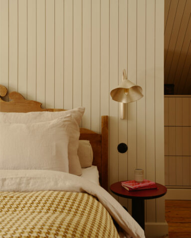 Une chambre avec son lit ancien en bois et des luminaires design