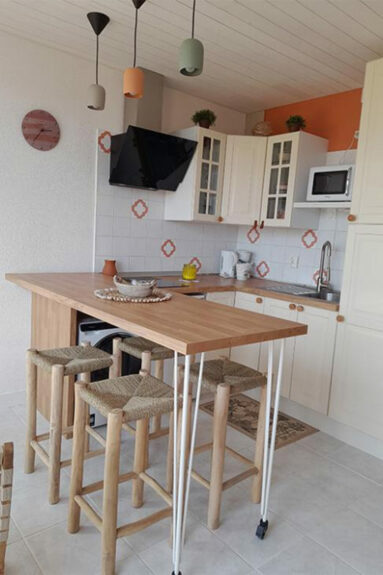 Aménagement d'un petit coin repas avec des pieds en métal blanc et un plan de travail en bois