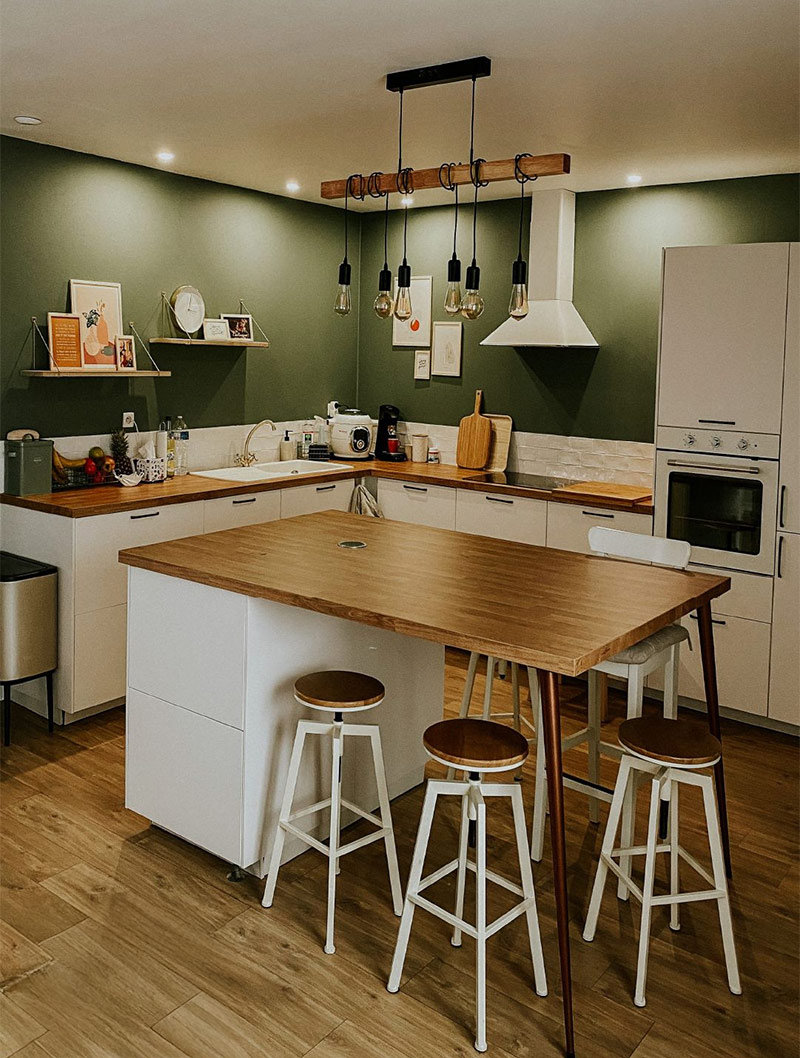 Un îlot central créé avec des pieds, un plan de travail en bois et un meuble bas de cuisine