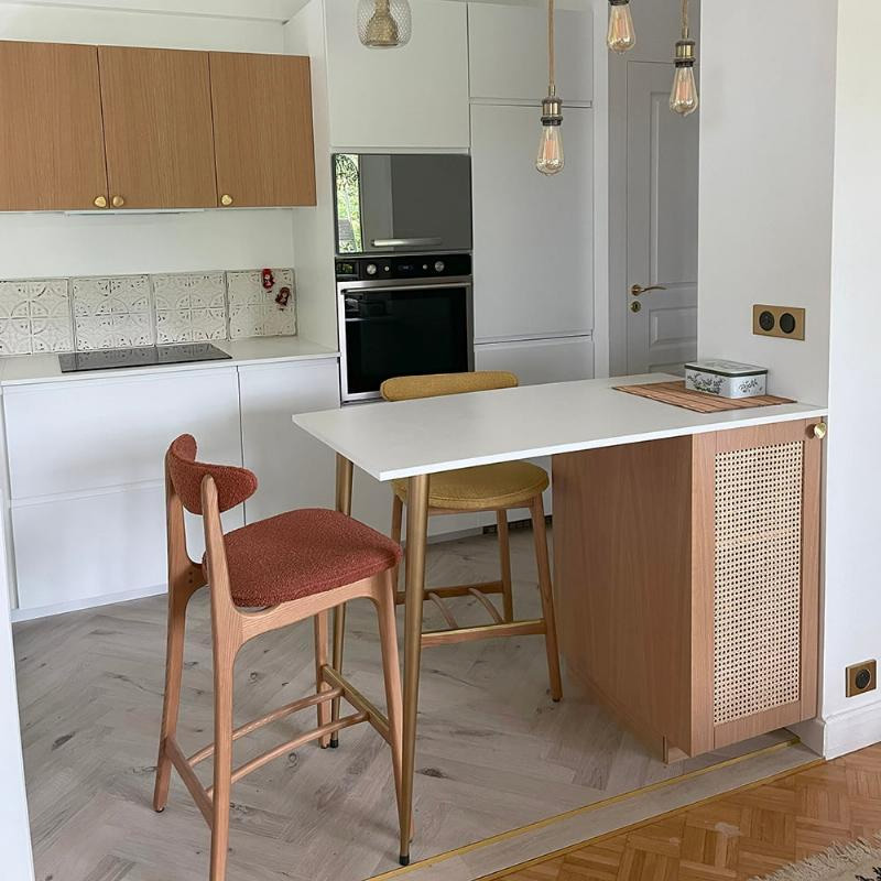 Un micro-bar aménagé pour fermer la cuisine avec un meuble bas, un plan de travail en MDF blanc et des pieds en métal