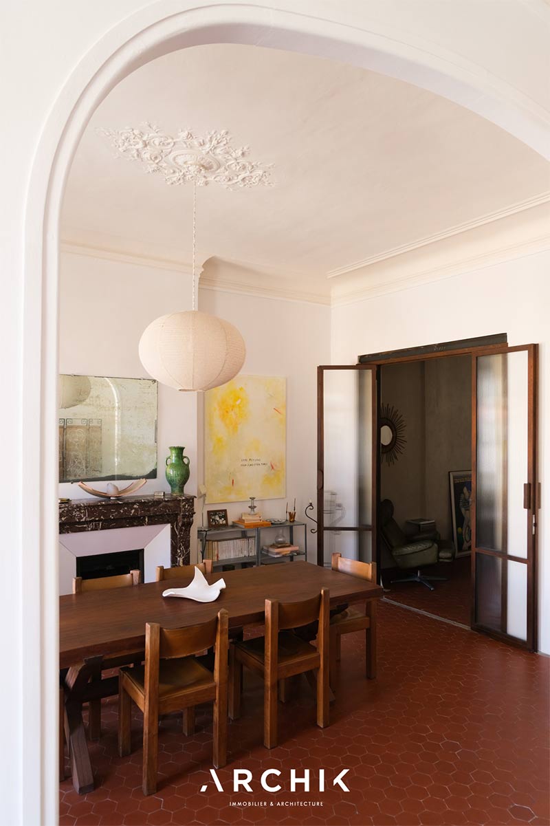 Le coin salle à manger ouvrant sur un espace bureau, fermée par une porte en verre Le coin salle à manger ouvrant sur un espace bureau, fermée par une porte en verre