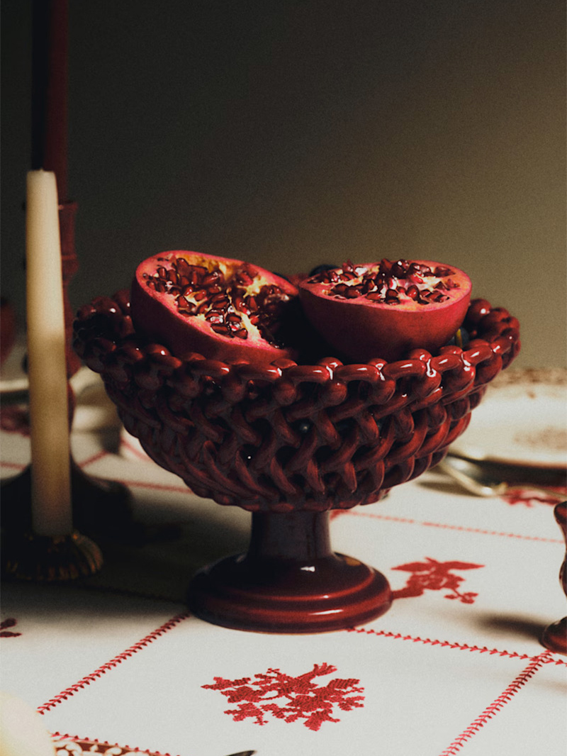 Coupe de fruits rouge, présentant une grenade coupée en deux