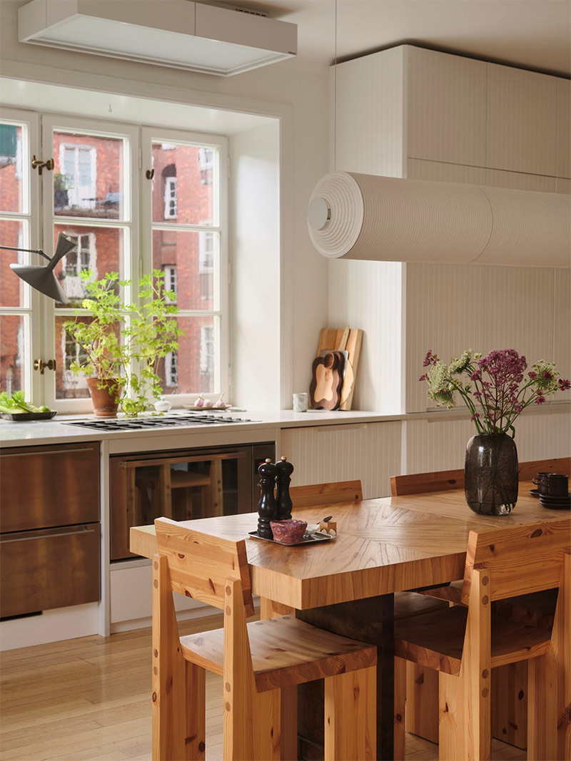 La grande table et chaises en bois massif Vaarnii, et la suspension cylindrique Lumeers donnent un esprit atelier à cet espace de repas