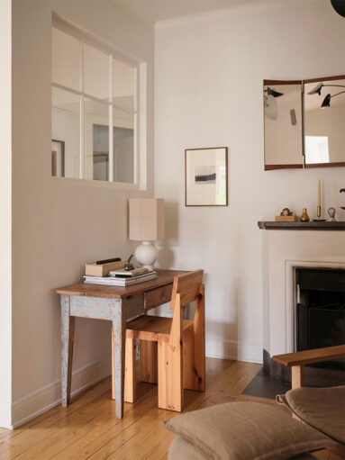Petit bureau ancien chiné et sa chaise massive en bois Vaarnii avec au-dessus une petite verrière atelier pour apporter de la lumière de la cuisine