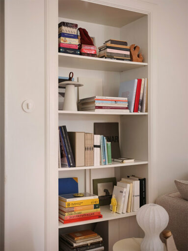 Étagère intégrée dna une alcôve, où sont mis en scène des livres et des objets décoratifs