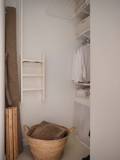 Le petit espace buanderie avec des rangements et une zone repassage, séchage