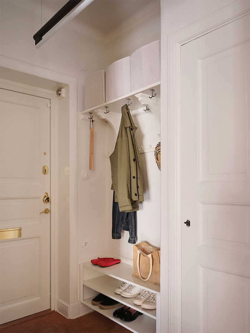 L'entrée de l'appartement avec une zone ouverte de rangement encastrée dans une alcôve