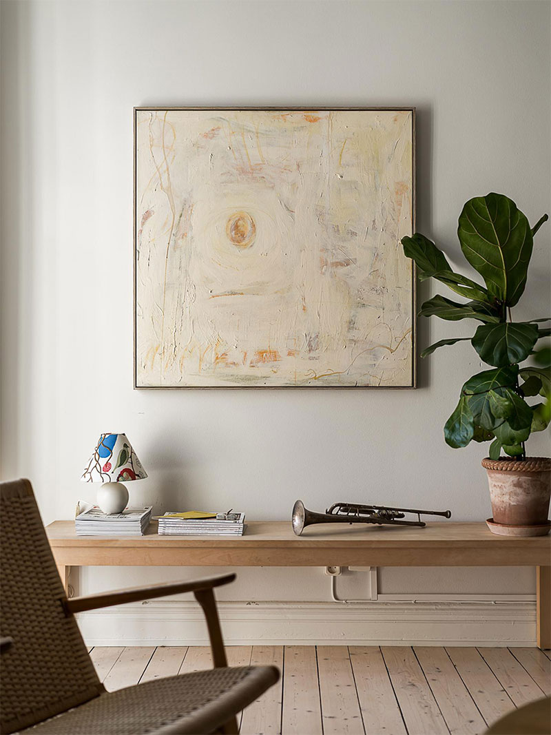 Un blanc en bois clair, une œuvre d'art, une plante, quelques objets chinés, pour un style épuré Un blanc en bois clair, une œuvre d'art, une plante, quelques objets chinés, pour un style épuré