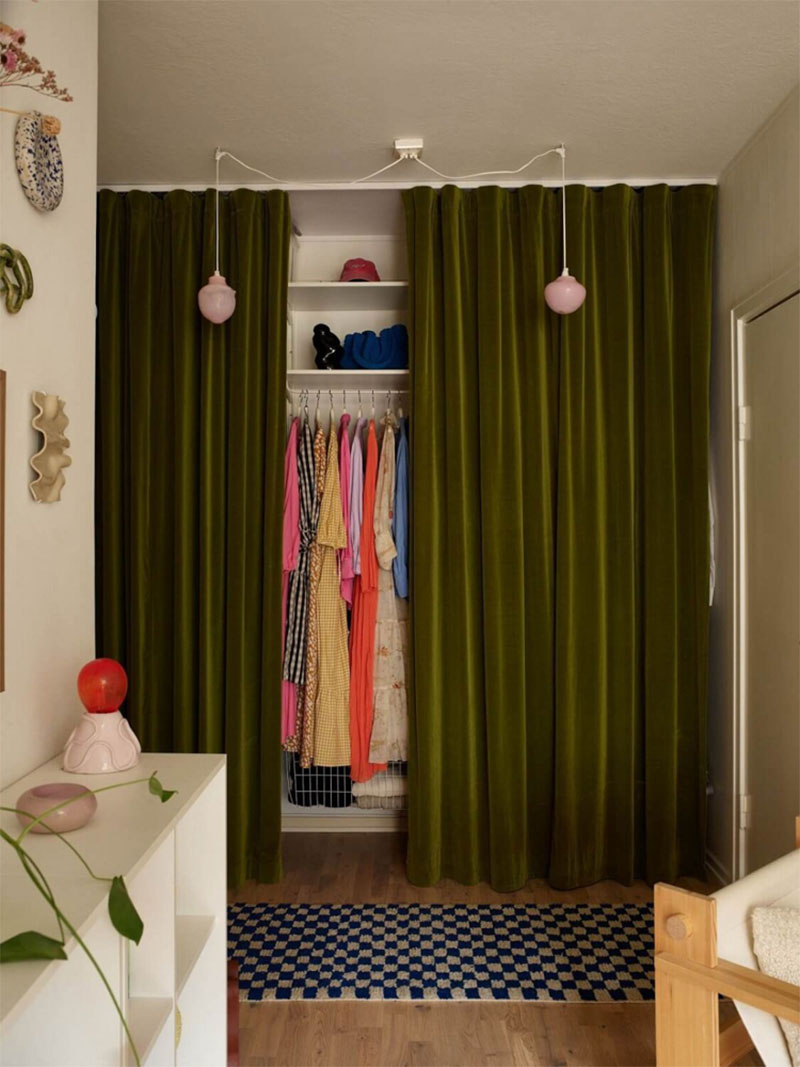 Grand rideau en velours vert pour fermer un dressing dans l'entrée de cet appartement suédois Grand rideau en velours vert pour fermer un dressing dans l'entrée de cet appartement suédois