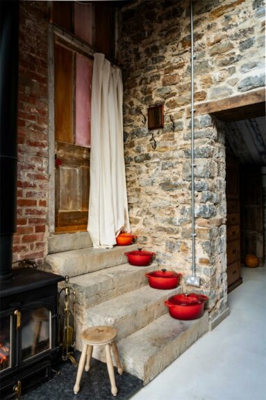 Les marches en pierre sur lesqulles sont rangées les cocottes en fonte orange du Creuset Les marches en pierre sur lesqulles sont rangées les cocottes en fonte orange du Creuset