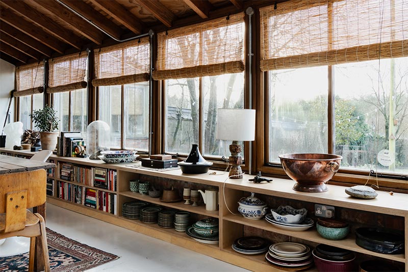 Les étagères ouvertes pour ranger vaisselles et livres, qui courent en dessous de la lignée de fenêtres Les étagères ouvertes pour ranger vaisselles et livres, qui courent en dessous de la lignée de fenêtres