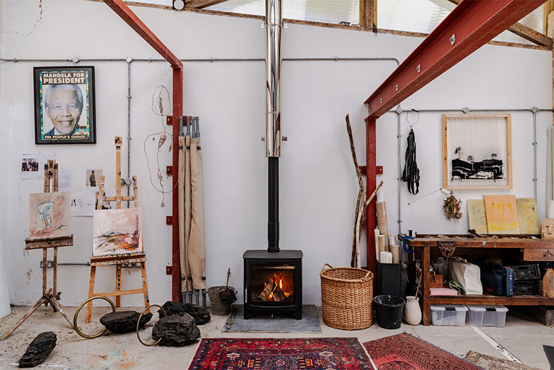 Vue du poêle à bois dans l'atelier et des objets mis en scène au mileiu des créations Vue du poêle à bois dans l'atelier et des objets mis en scène au mileiu des créations