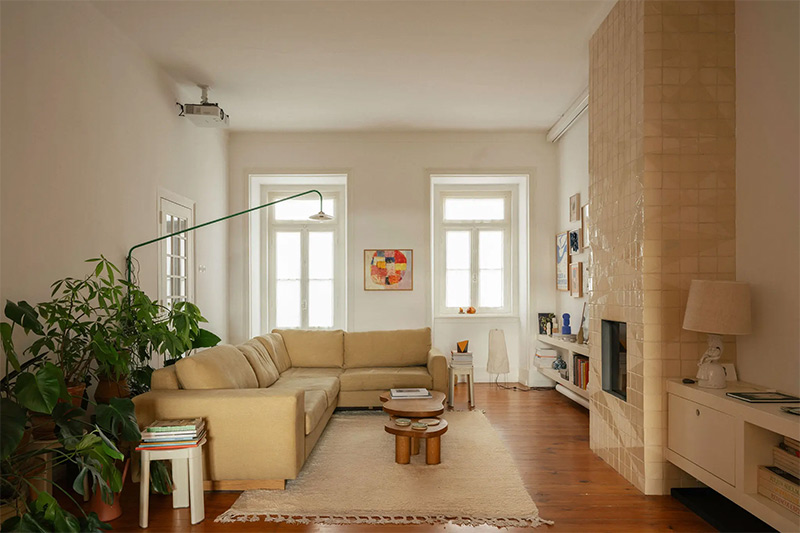 Le salon avec un grand canapé d'angle jaune, décoré d'objets design et artisanaux