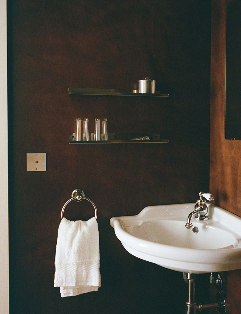 Salle d'eau en boiserie sombre et lavabo rétro