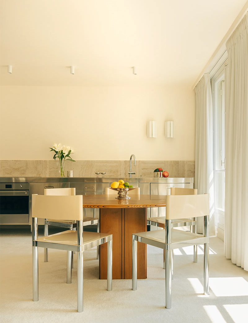 Cuisine en inox, chaise chromée et murs en jaune clair