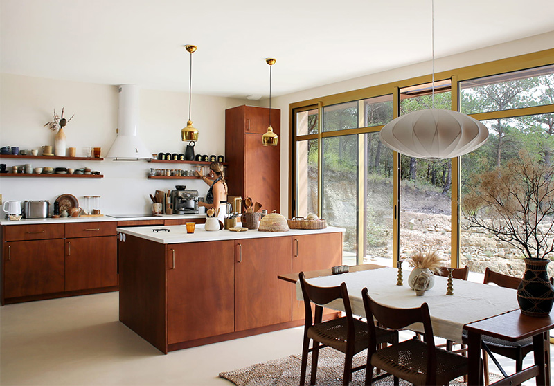 Une cuisine ouverte en bois, type okoumé, une essence bois foncée et chaude, pour un style moderniste