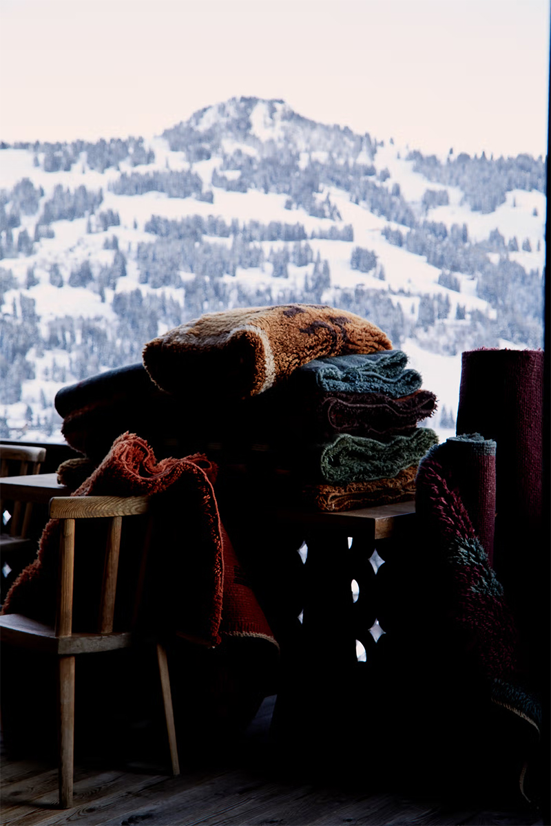 Les tapis Beni Rugs mis en scène sur la terrasse avec vue sur la montagne