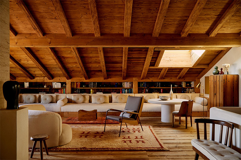 Le salon aménagé sous les combles avec une grande banquette placée sous la pente du toit