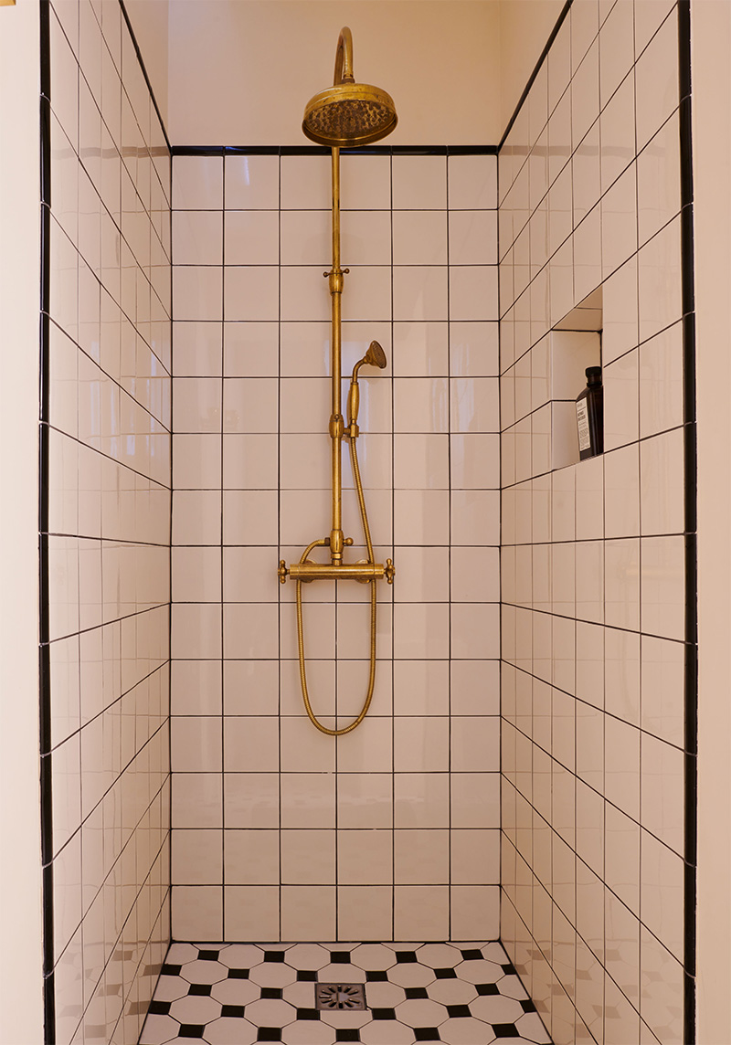 Douche, esprit Art Déco en noir et blanc avec une colonne de douche en laiton