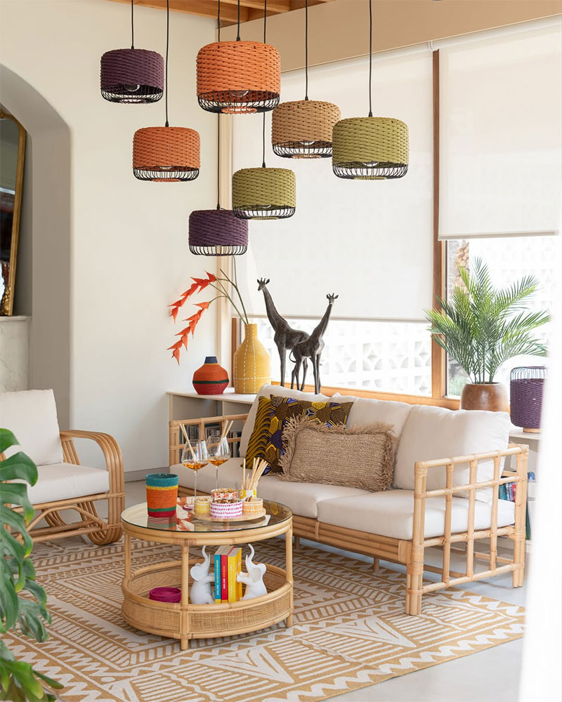 Un salon à l'esprit indoor outdoor en rotin avec une collection de suspension de couleur en fibres naturelles pour un style ethnique