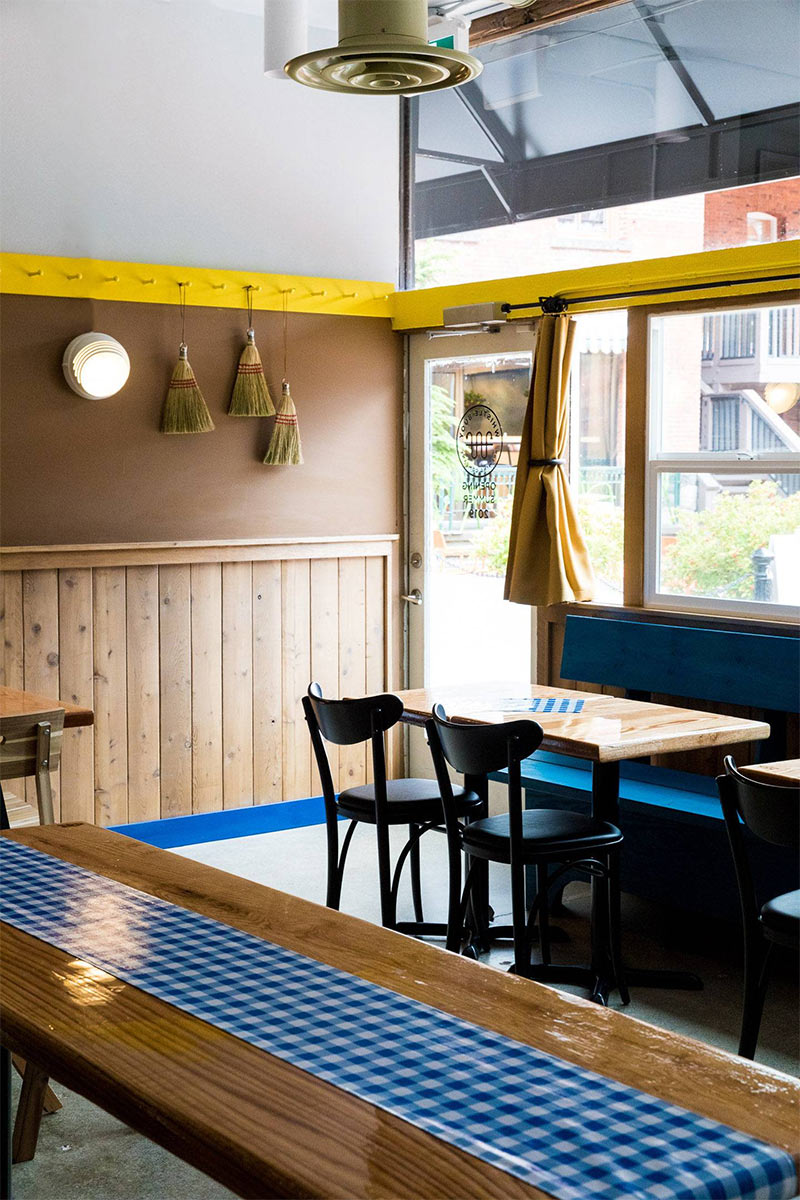 Brasserie Whistle Buoy présentant entre autres des références à l'approche shaker, mélange de bois avec des touches de couleurs bleues et jaunes