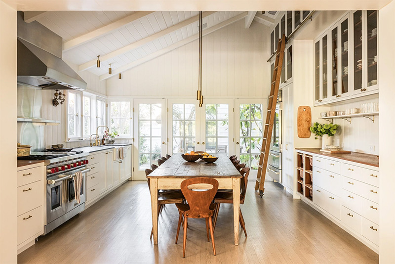 La vaste cuisine blanc crème avec des aménagements de chaque côté, montant jusqu’au plafond et de nombreux plans de travail