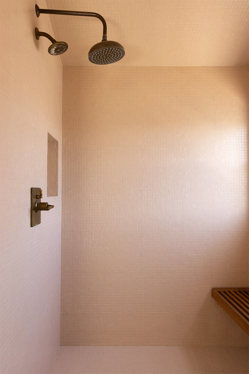 Espace douche en mosaïque rose pâle, avec colonne de douche encastrée noire