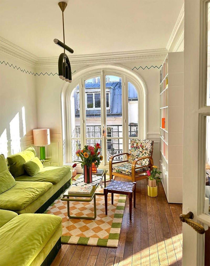 Le canapé vert chartreuse qui accroche le regard dans cet appartement haussmannien parisien