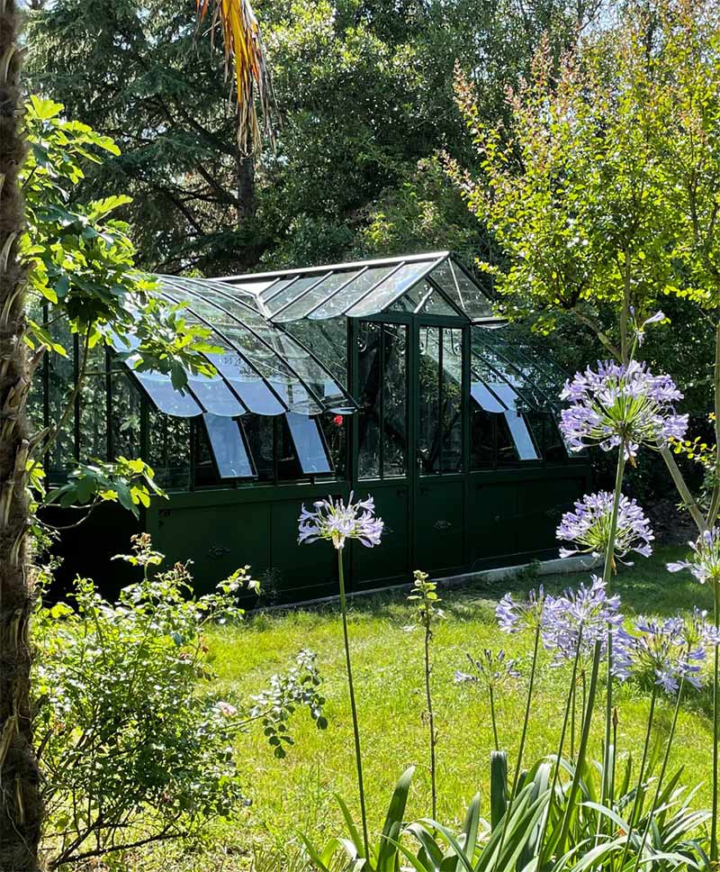 Serre Mirabeau de chez Lams avec toit arrondi et chien assis, dans un jardin bucolique Serre Mirabeau de chez Lams avec toit arrondi et chien assis, dans un jardin bucolique
