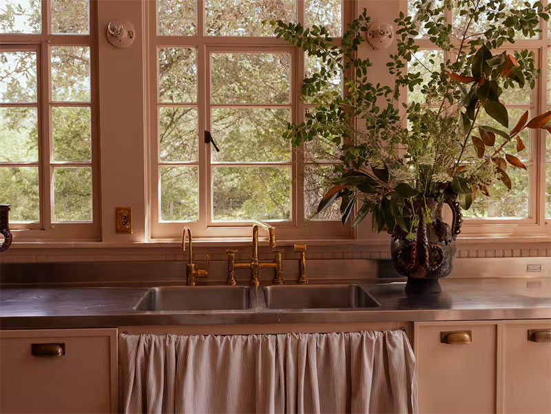 Les meubles de cuisine aux façades cadre, agrémentée de poignées en laiton