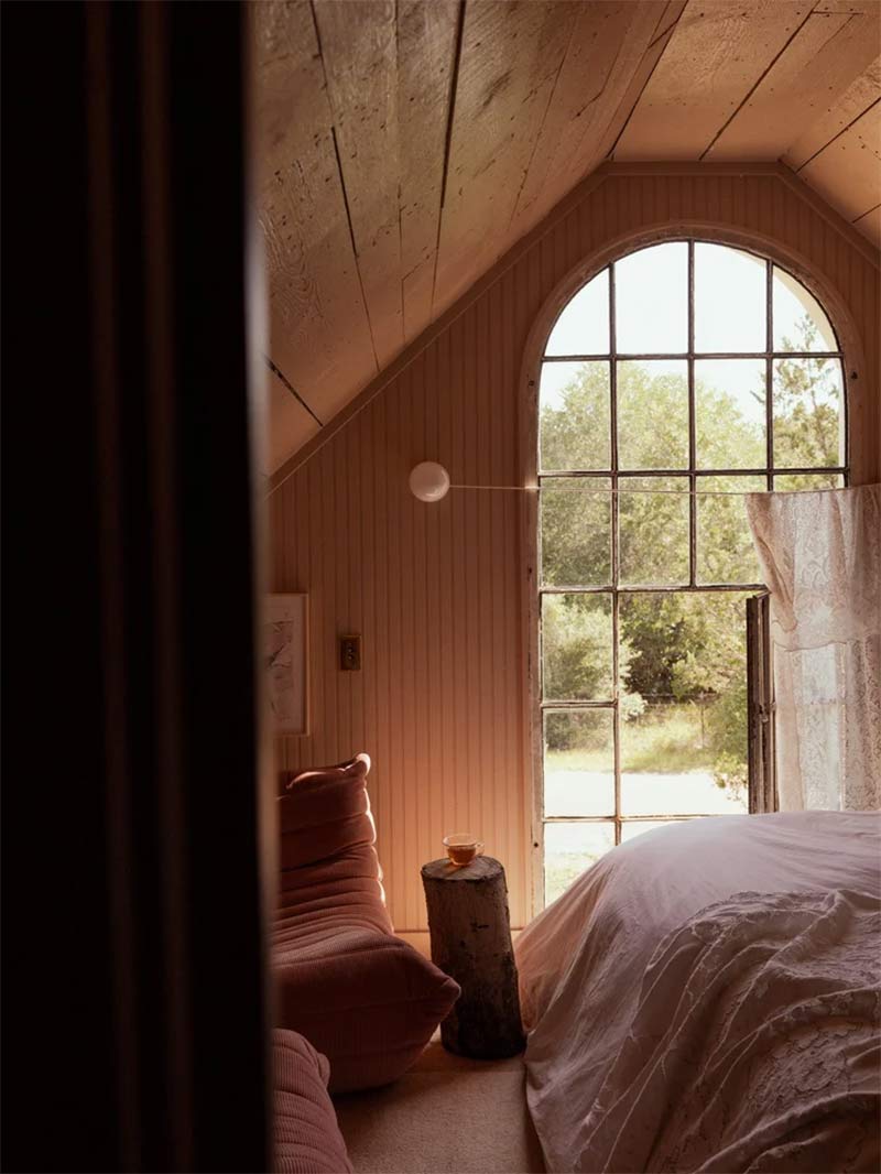 La chambre principale et sa baie vitrée ancienne donnant sur l'extérieur