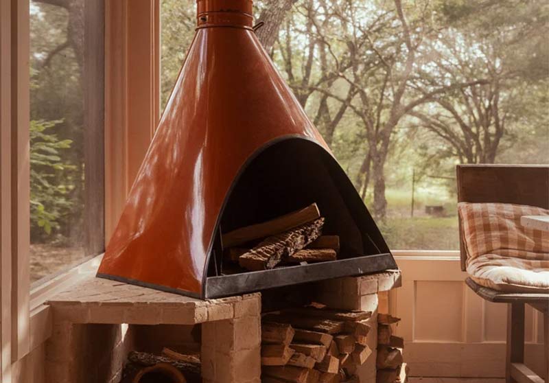 La cheminée extérieure vintage installée sous le porche protégée de la maison