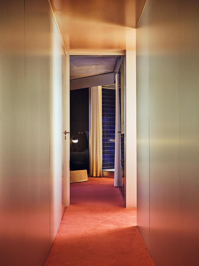 Les couloirs moquettés de rose orangé qui conduisent aux chambres