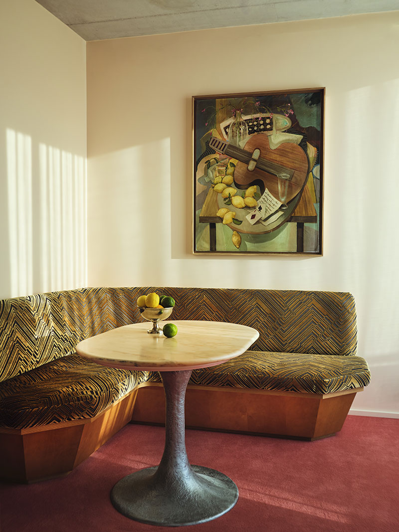 La suite 62 de l'hôtel Bus Palladium avec sa moquette rouge rosé et sa banquette sur mesure couverte d'un tissu en velours