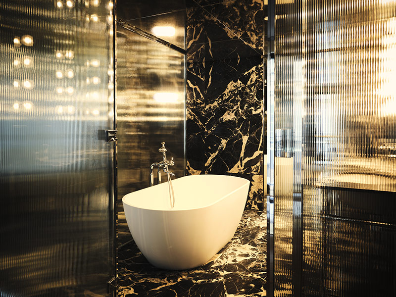 La salle de bains en marbre veiné noir et blanc de la suite Dali, au décor Glamour Rock