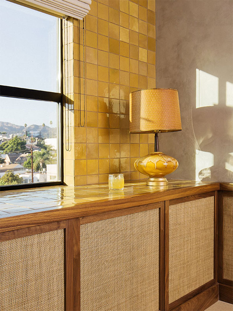 Meubles en placage cannage et murs en faïence jaune ocre en fond dans une chambre du Silver Lake Pool & Inn