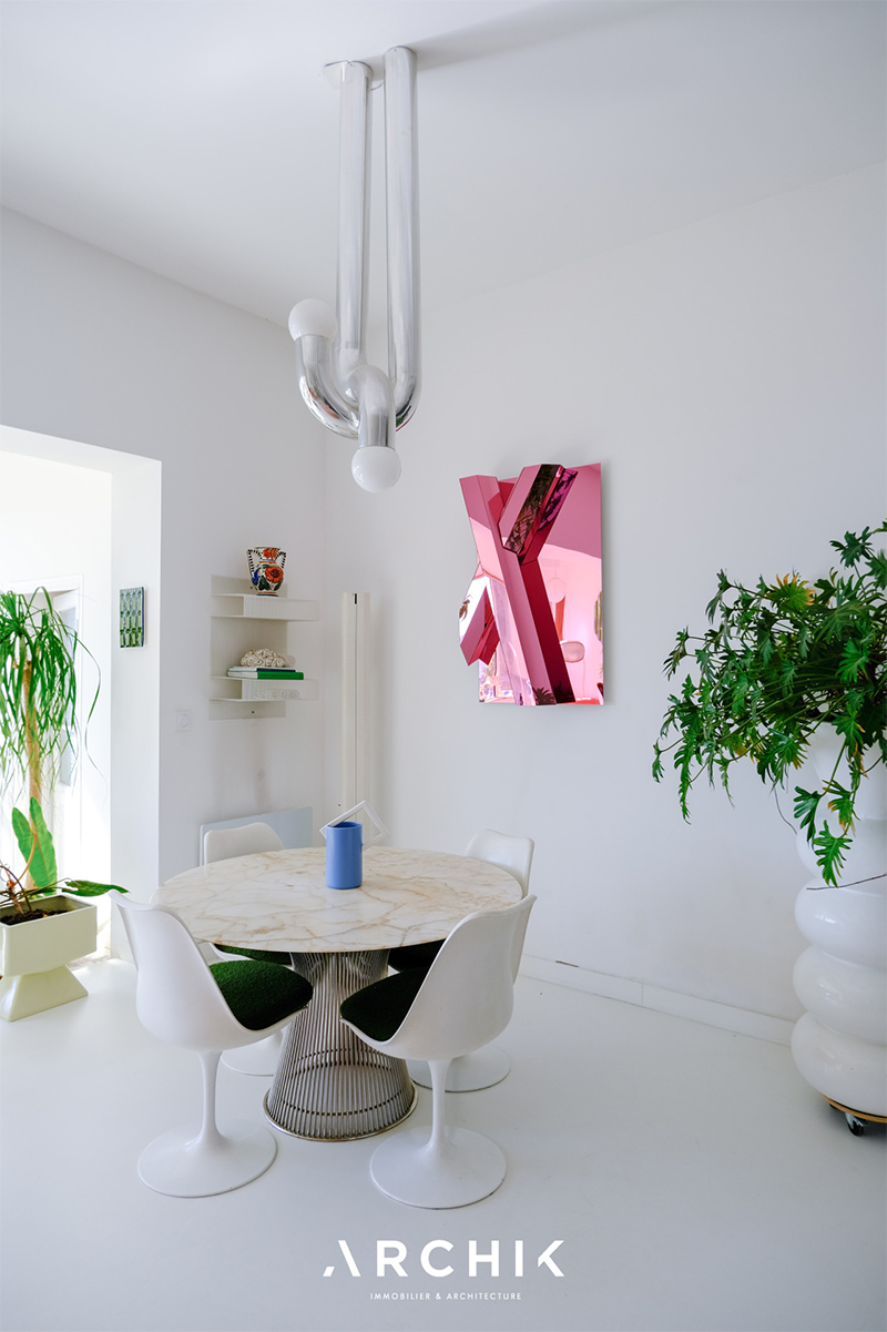 Le coin repas composé de mobilier vintage, éclairé par un luminaire Axel Chay Le coin repas composé de mobilier vintage, dont les chaises Tulipe, éclairé par un luminaire Axel Chay