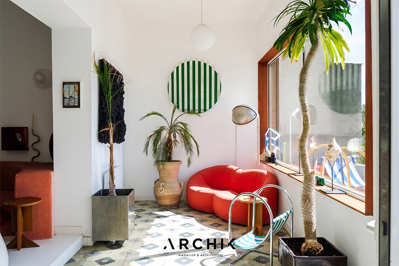 L'entre-salle entre le séjour et la terrasse, présentant un sol en carreaux de ciment et du mobilier design L'entre-salle entre le séjour et la terrasse, présentant un sol en carreaux de ciment et du mobilier design