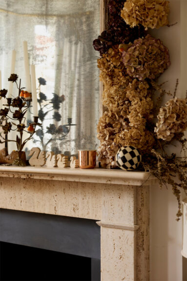 Cheminée et miroir d'époque, décorée avec des têtes d'hortensia séchées pour un style romantique