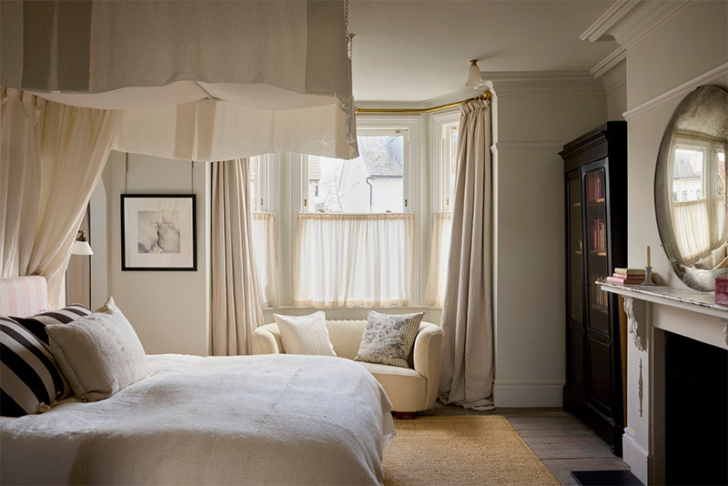 La chambre parentale dans les tonalités de blanc crème avec un ciel de lit moderne blanc