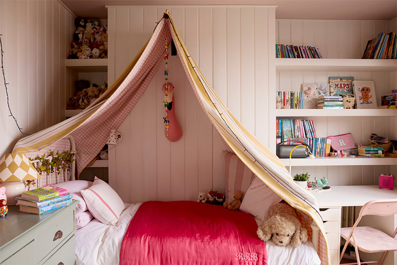 Un lit d'enfant avec un ciel de lit simple pour une chambre de petite fille moderne
