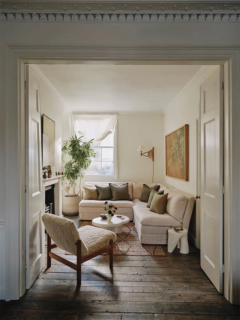 Un petit salon dans un appartement ancien, dont l'angle est judicieusement occupé par un canapé d'angle