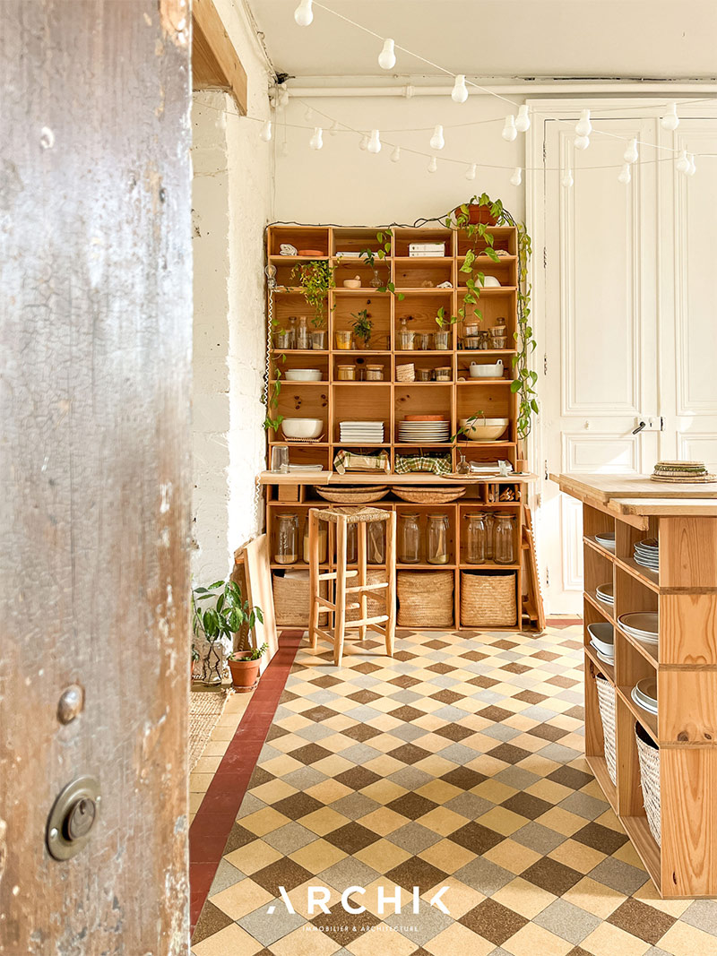 La cuisine au sol, meublée avec des meubles casiers en pin