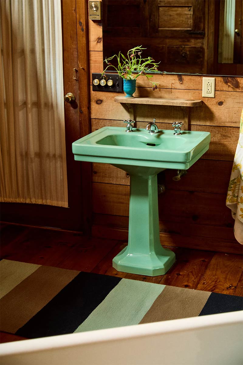 La salle d'eau et son lavabo sur pied vintage en vert menthe