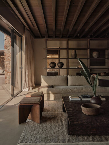 Le salon dans un style design inspiré des tonalités et textures wabi sabi Le salon dans un style design inspiré des tonalités et textures wabi sabi : tapis en fibres naturelles, canapé en lin, essence de bois sombre, poterie en terre cuite
